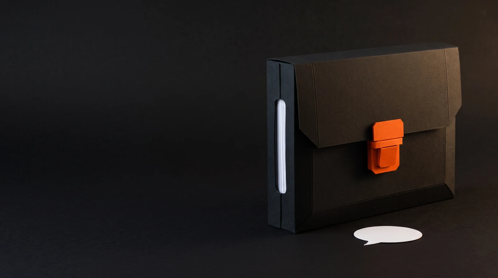 Un estuche negro para documentos cerrado con un broche naranja, con papeles blancos seguros en su interior.